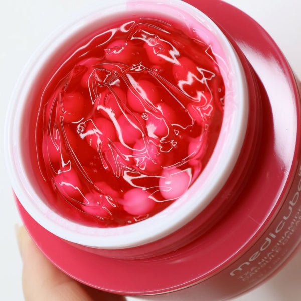 medicube TXA Niacinamide Capsule Cream 55g in open jar showing vibrant red gel texture for even tone benefits