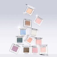 Various ultra-pigmented eyeshadows in soft pastel and neutral shades in clear square compacts on light background