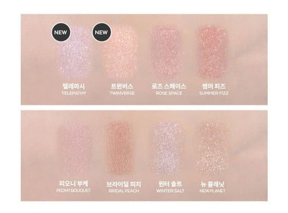 Eight swatches of ultra-pigmented eyeshadows in soft pink and peach tones with shimmer on light skin.