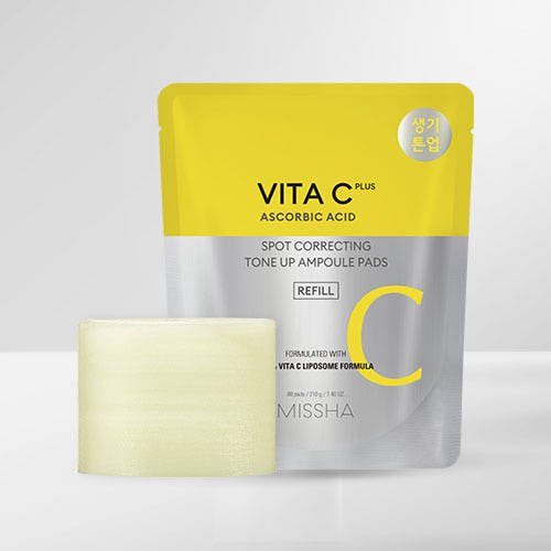 Yellow and silver refill pouch of brightening spot correcting ampoule pads with a visible textured pad on a white background