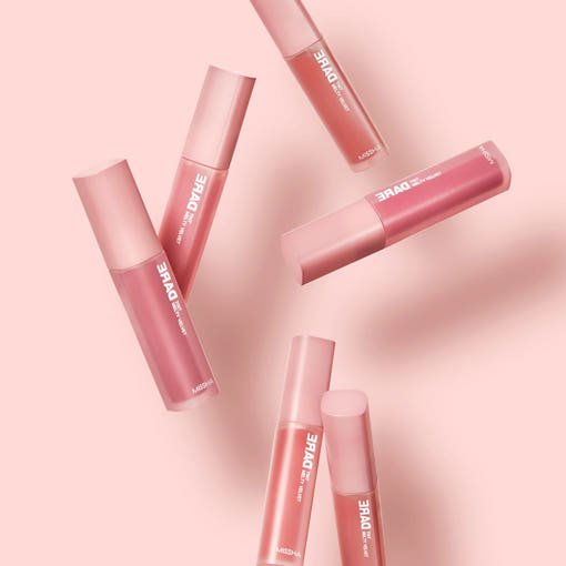 Set of six smooth-application lip tint tubes in muted pinks arranged on pale pink background