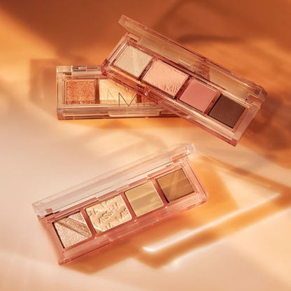 Three sleek palettes with versatile neutral and shimmer shades in transparent cases on warm beige surface lighted by soft shadows