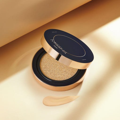 Open cushion compact with gold and black lid showing high coverage foundation cushion and swatch on beige background