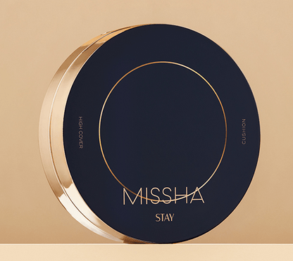 Round sleek dark blue cushion compact with gold accents highlighting high coverage makeup product on beige background