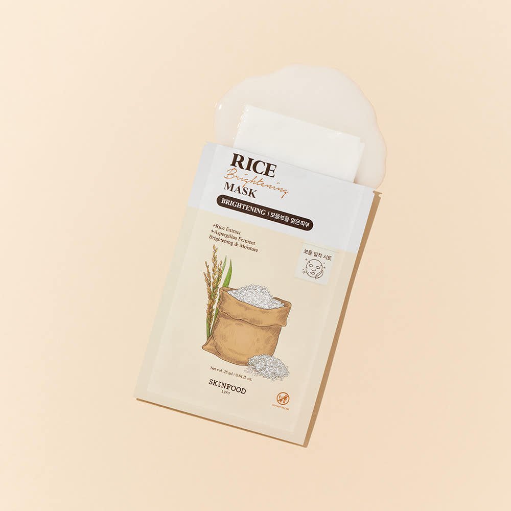 Brightening rice mask sachet with spilled moisturizing essence on soft beige background for hydration care
