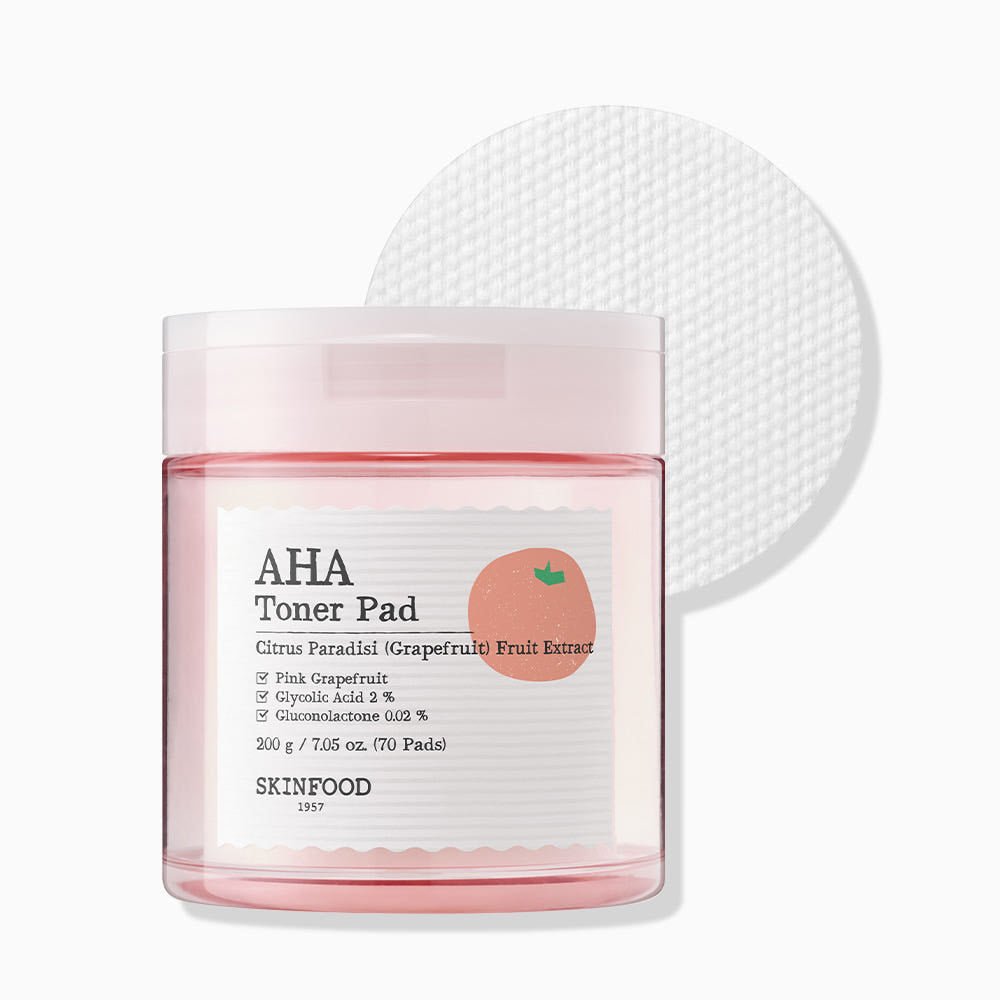 Clear pink jar of toner pads with grapefruit illustration and gentle exfoliating formula label on white background