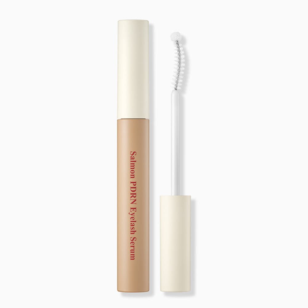 Slim beige eyelash serum tube with curved applicator brush for strengthening lashes on white background