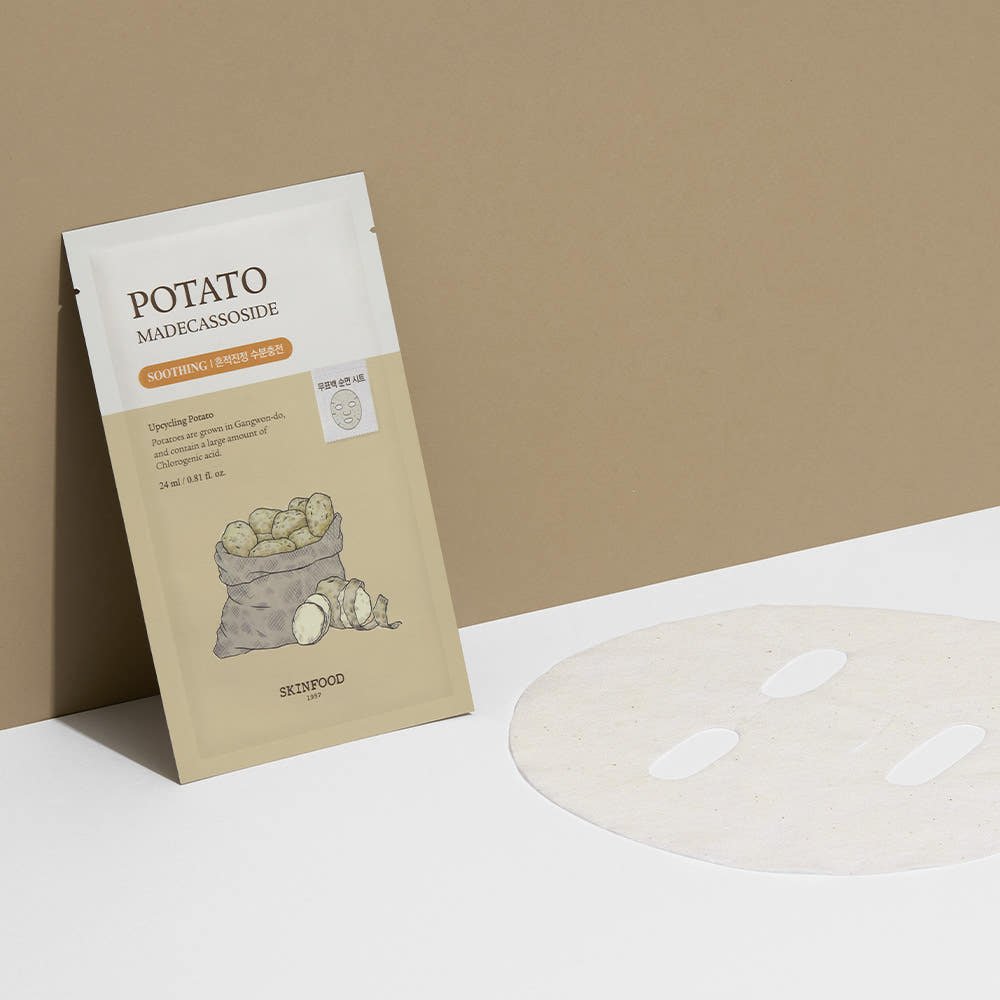 Beige and white potato mask sheet package beside unfolded soothing relief facial sheet mask on neutral background