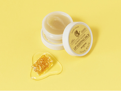 Open jar of honey sugar lip mask with smooth texture beside honeycomb piece and golden honey on yellow background