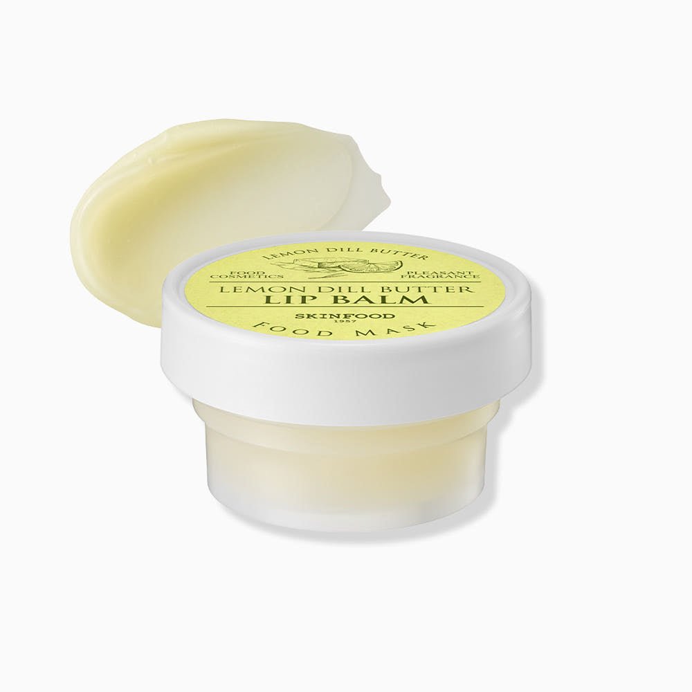 Small jar of pale yellow lemon dill butter lip balm with smooth texture swatch beside container on white background