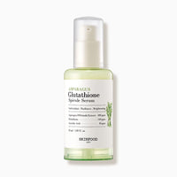 Clear bottle of light green brightening serum with white pump and label featuring asparagus illustration