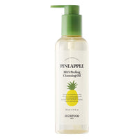 Clear bottle of gentle cleansing oil with green pump and yellow pineapple graphic for exfoliating skincare routine