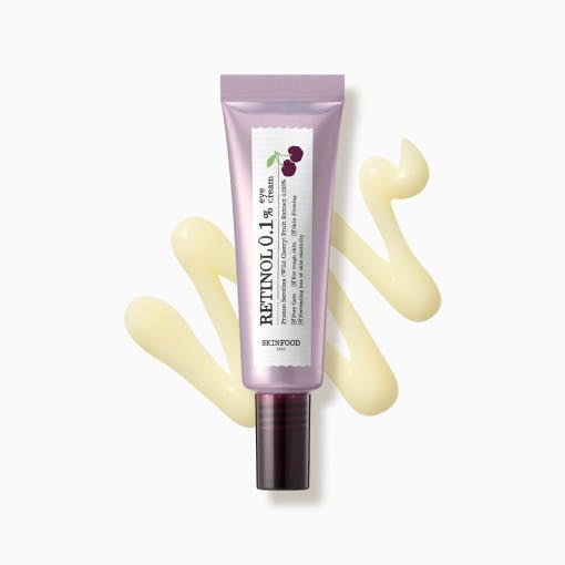Purple tube of retinol eye cream with cherry illustration beside light yellow cream swatch on white background