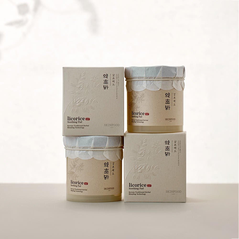 Stacked beige jars and boxes of licorice soothing pads featuring subtle herbal embossing and natural calming design