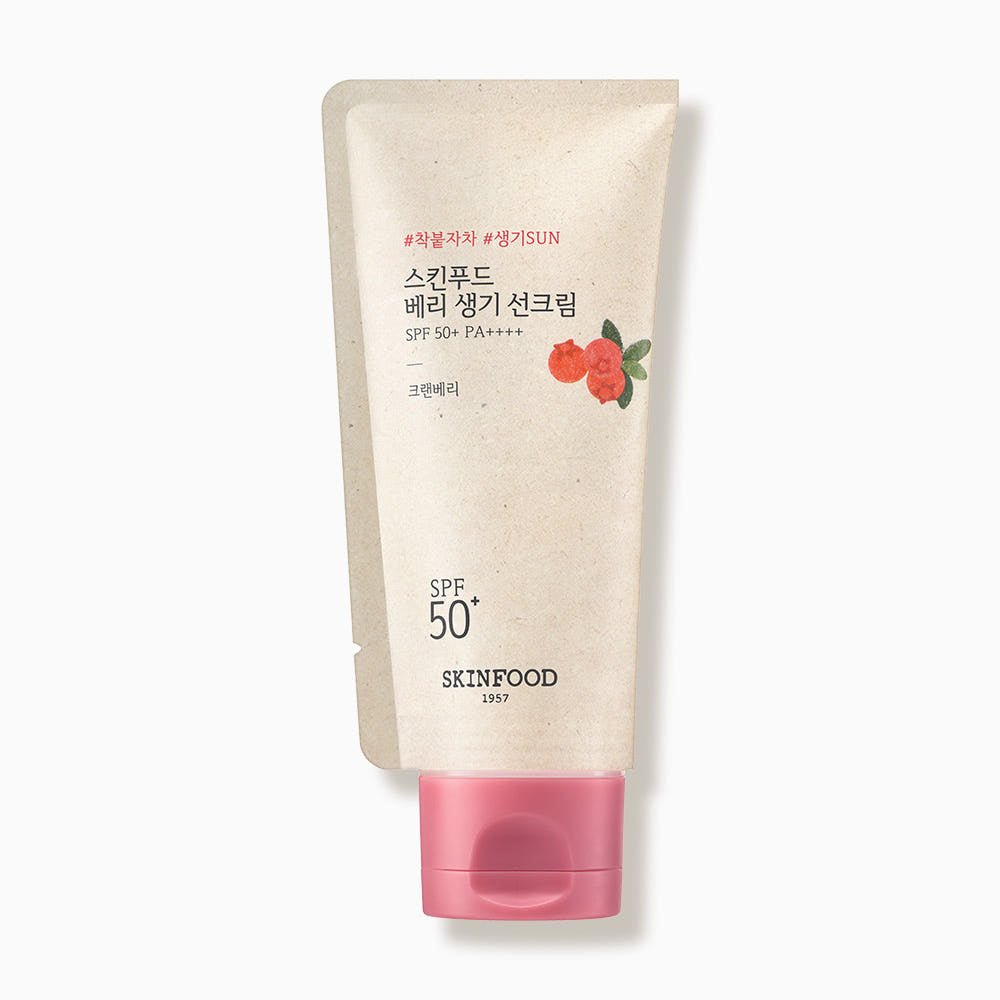 Tube of SPF50+ PA++++ sun cream with a soft beige body and pink cap featuring a small red berry illustration