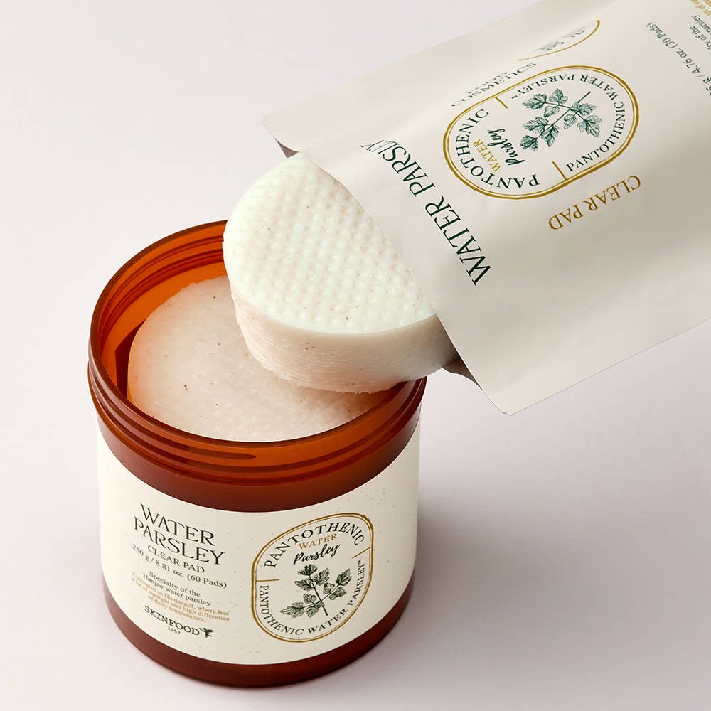 Round textured skincare pads partially pulled from amber container with white refill pouch labeled with parsley illustration