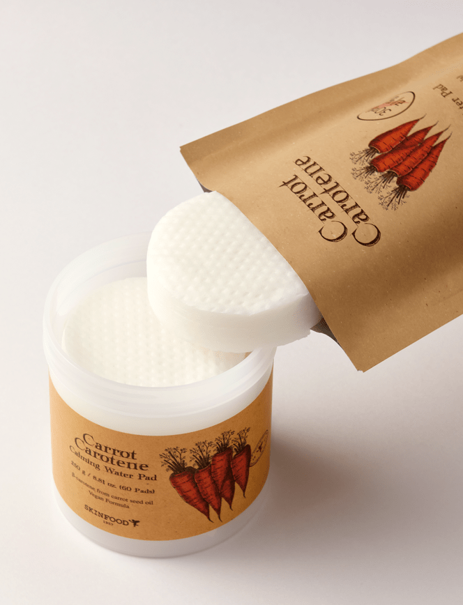 Round white calming water pads partially removed from eco-friendly brown refill pouch and plastic jar with carrot illustration