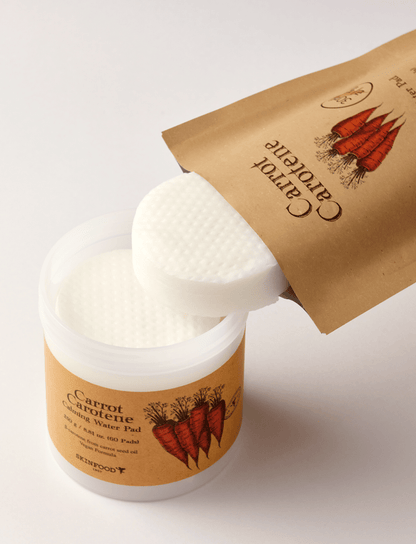 Round white calming water pads partially removed from eco-friendly brown refill pouch and plastic jar with carrot illustration