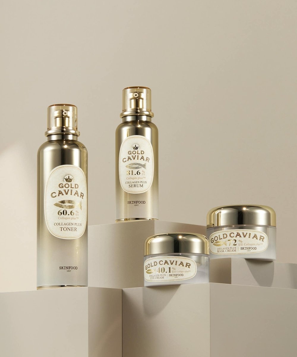 Four SKINFOOD Gold Caviar Collagen Plus skincare products in elegant gold and white packaging on neutral geometric blocks