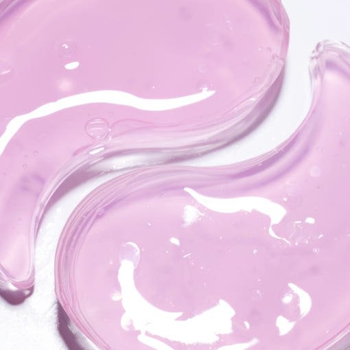 Close-up of translucent pink hydrogel eye patches with smooth, glossy texture highlighting de-puffing skincare benefit