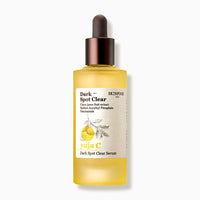 Frosted yellow serum bottle with brown dropper cap and label highlighting brightening ingredients for dark spot care