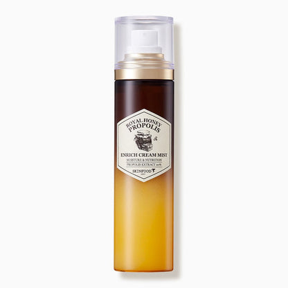 Tall spray bottle with gradient amber-to-brown color containing moisturizing propolis cream mist with gold and clear cap