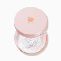 Open pink compact with white loose powder and a small peach illustration on the lid