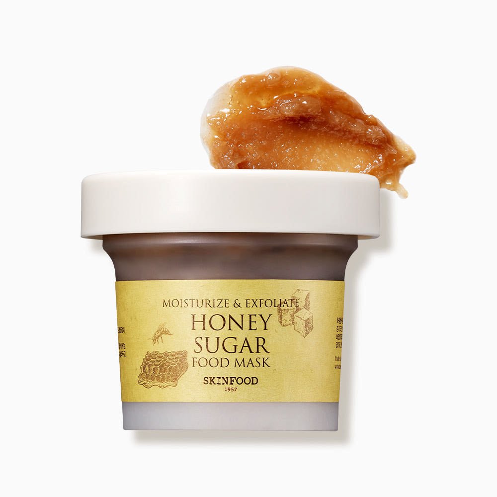 Jar of honey sugar food mask with creamy textured honey-colored product on white background