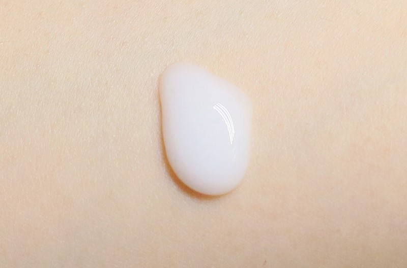 Smooth white serum drop on light skin illustrating nourishing skincare formula texture