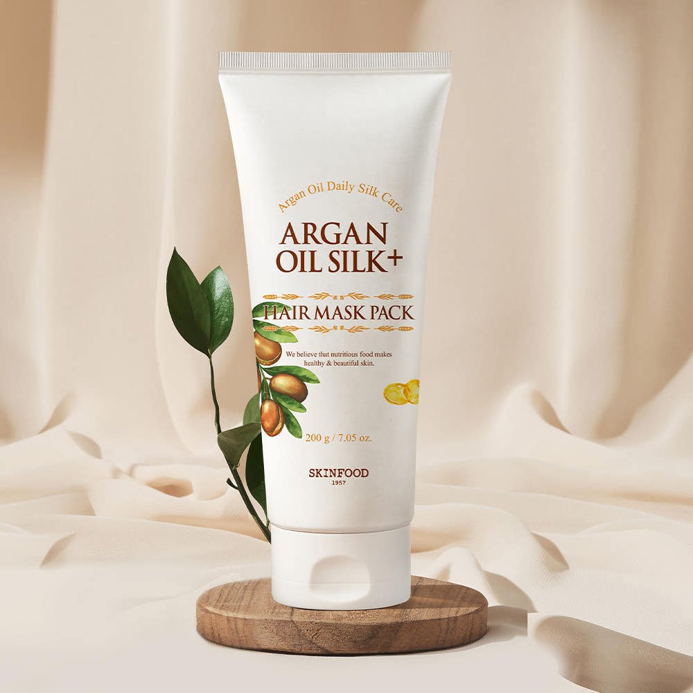 SKINFOOD Argan Oil Silk Plus Hair Mask Pack 200g tube with plant and wooden base showcasing nourishing hair care benefits