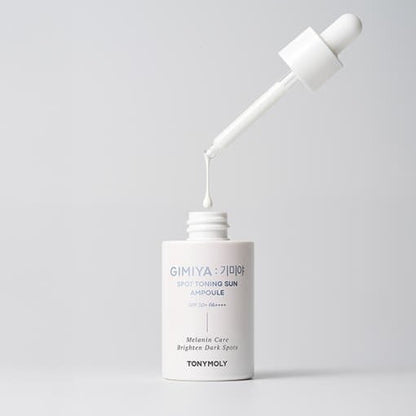 White dropper bottle of sun protection ampoule with a drop about to fall back into the open container on gray background
