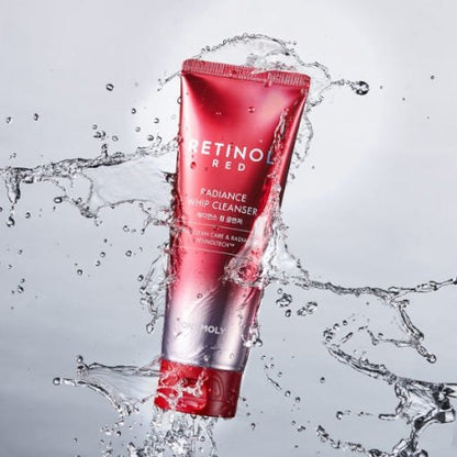Red and silver tube of retinol radiance whip cleanser surrounded by splashing water droplets on light background