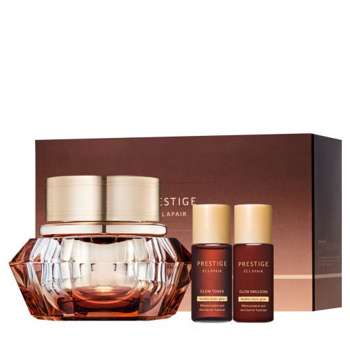 Luxury amber-tinted glass jar and two glow skin care bottles with gold caps in a gradient brown gift box