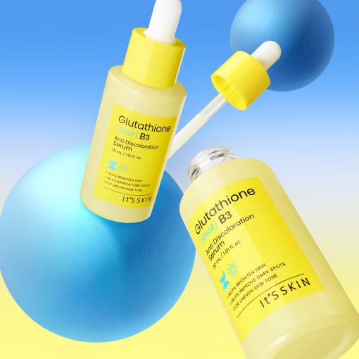 Two yellow dropper bottles of brightening serum with clear liquid, arranged with blue spheres on gradient background