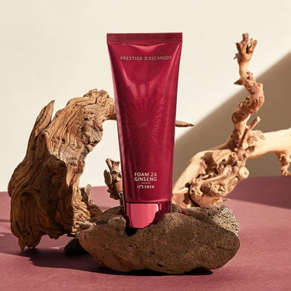 Deep cleansing foam in sleek burgundy tube displayed on natural textured stones with wood accents in soft light