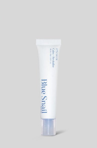White squeeze tube of Blue Snail serum with blue text and clear cap on neutral background