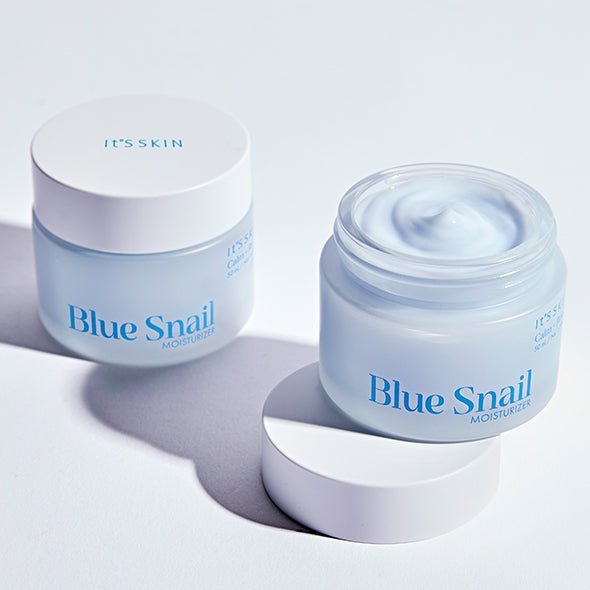 Two pale blue skincare jars with white lids, one open showing creamy moisturizer inside for hydration boost