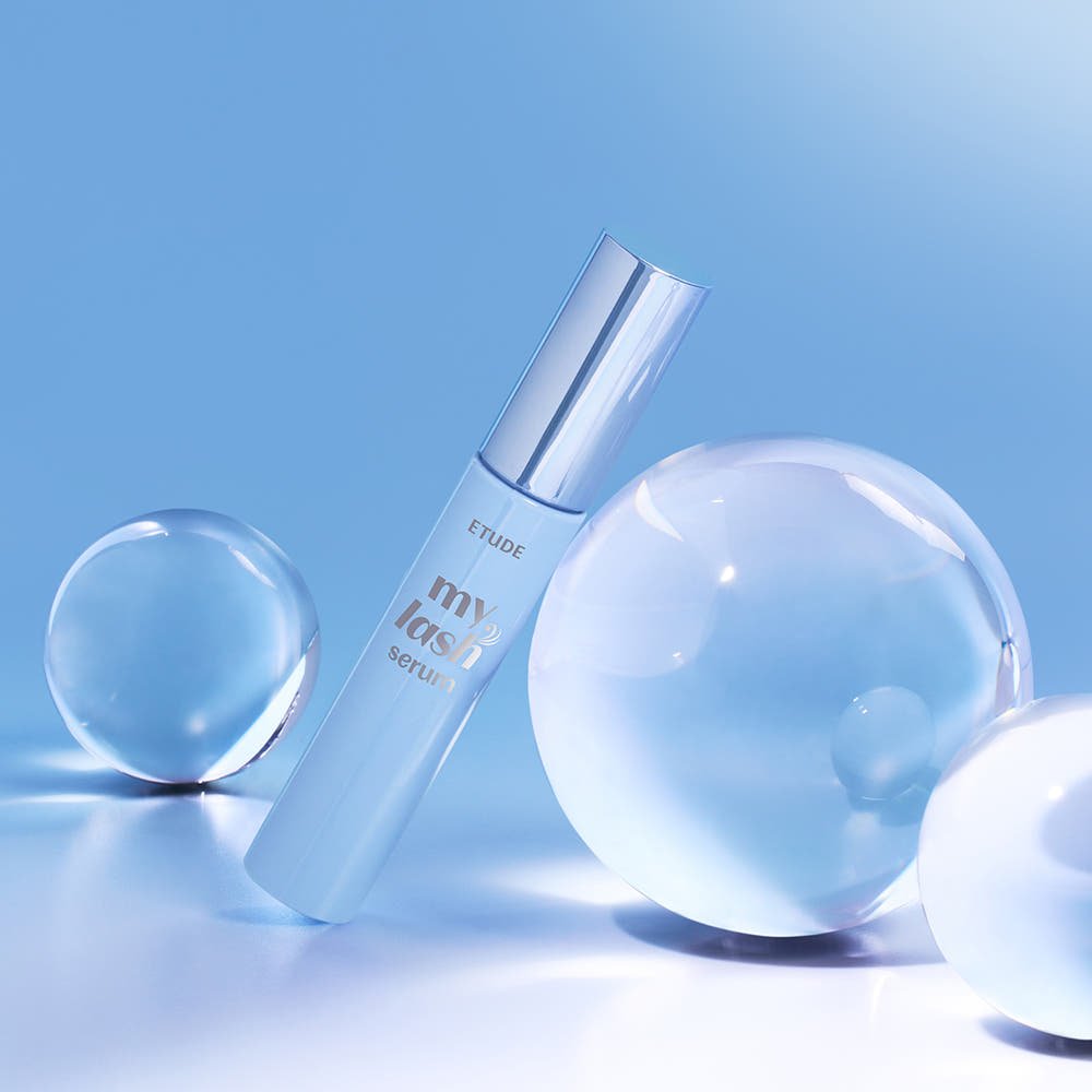 ETUDE My Lash Serum 18g with sleek silver cap and clear droplets on glossy blue surface highlighting lash strengthening benefits