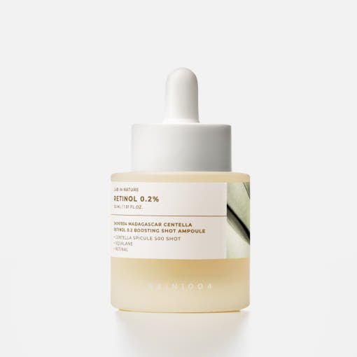 Frosted glass dropper bottle with pale yellow serum labeled retinol 0.2% for wrinkle reduction on white background