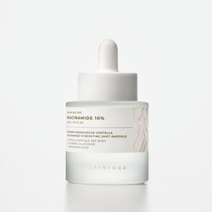 Frosted glass dropper bottle of brightening skin serum with niacinamide and centella extract on white background