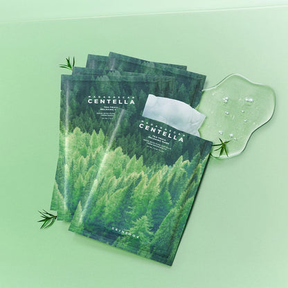 Green sachets of Centella tea-trica relaxing face mask with clear gel and small plant sprigs on light green background