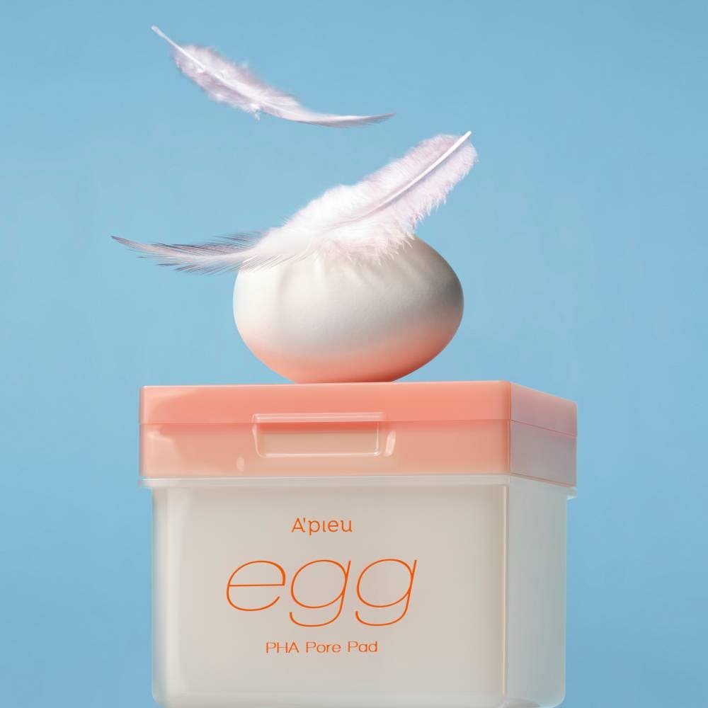A'pieu Egg PHA Pore Pad 180g/80ea with white egg-shaped pad and soft feathers symbolizing gentle exfoliation