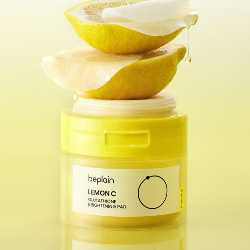beplain Lemon C Glutathione Brightening Pad 70ea in yellow jar with lemon halves and glowing liquid drop