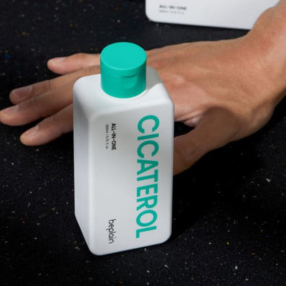 beplain Cicaterol ALL-IN-ONE 200ml bottle with green cap on dark textured surface beside hand showing wrinkle improvement benefits
