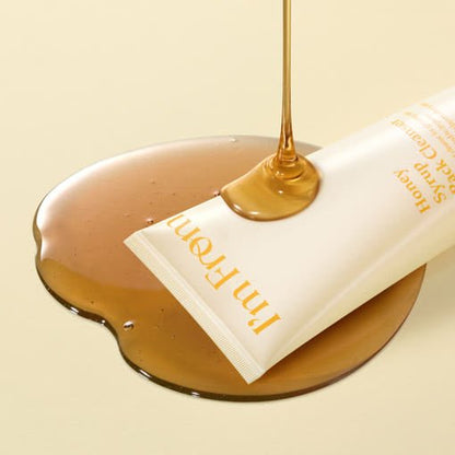 Tube of cleanser with golden honey syrup pouring over it on a smooth beige background for deep cleansing care