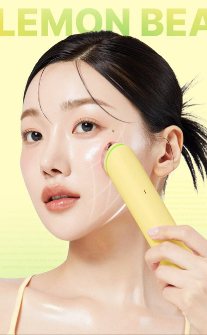 medicube AGE-R Booster Pro #Lemon device applied to woman's cheek with smooth glowing skin on yellow background