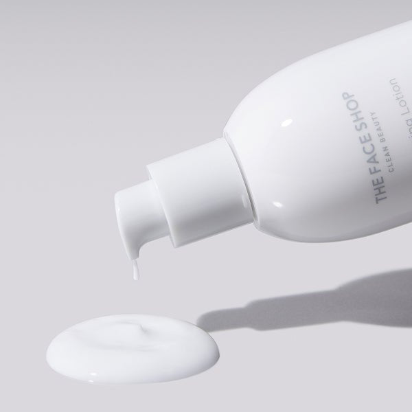 White lotion being dispensed from sleek white pump bottle with smooth lightweight skincare texture on gray background