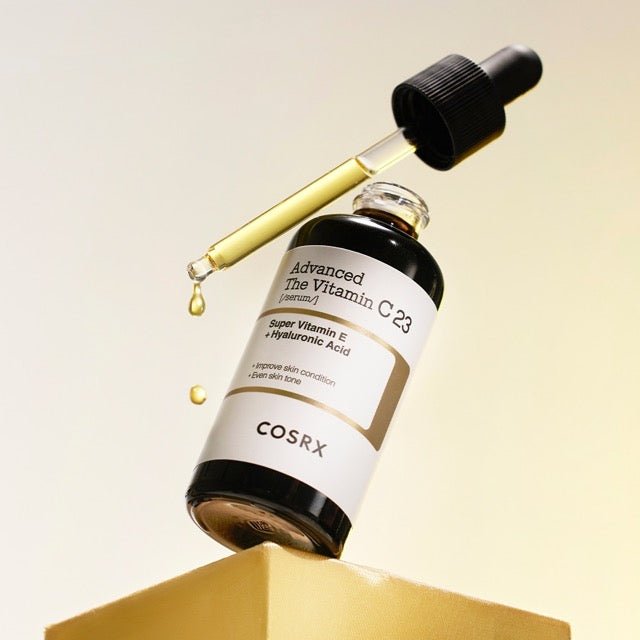 Dark glass dropper bottle with yellow serum highlighting brightening and hydration benefits on neutral background