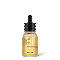 Small transparent glass dropper bottle filled with golden propolis ampoule and matte black ribbed cap on white background