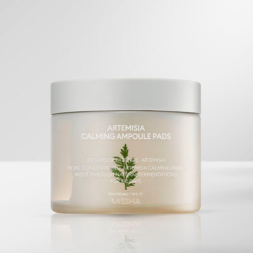 Translucent jar of soothing ampoule pads with simple white lid and minimal green Artemisia leaf design on soft gray background